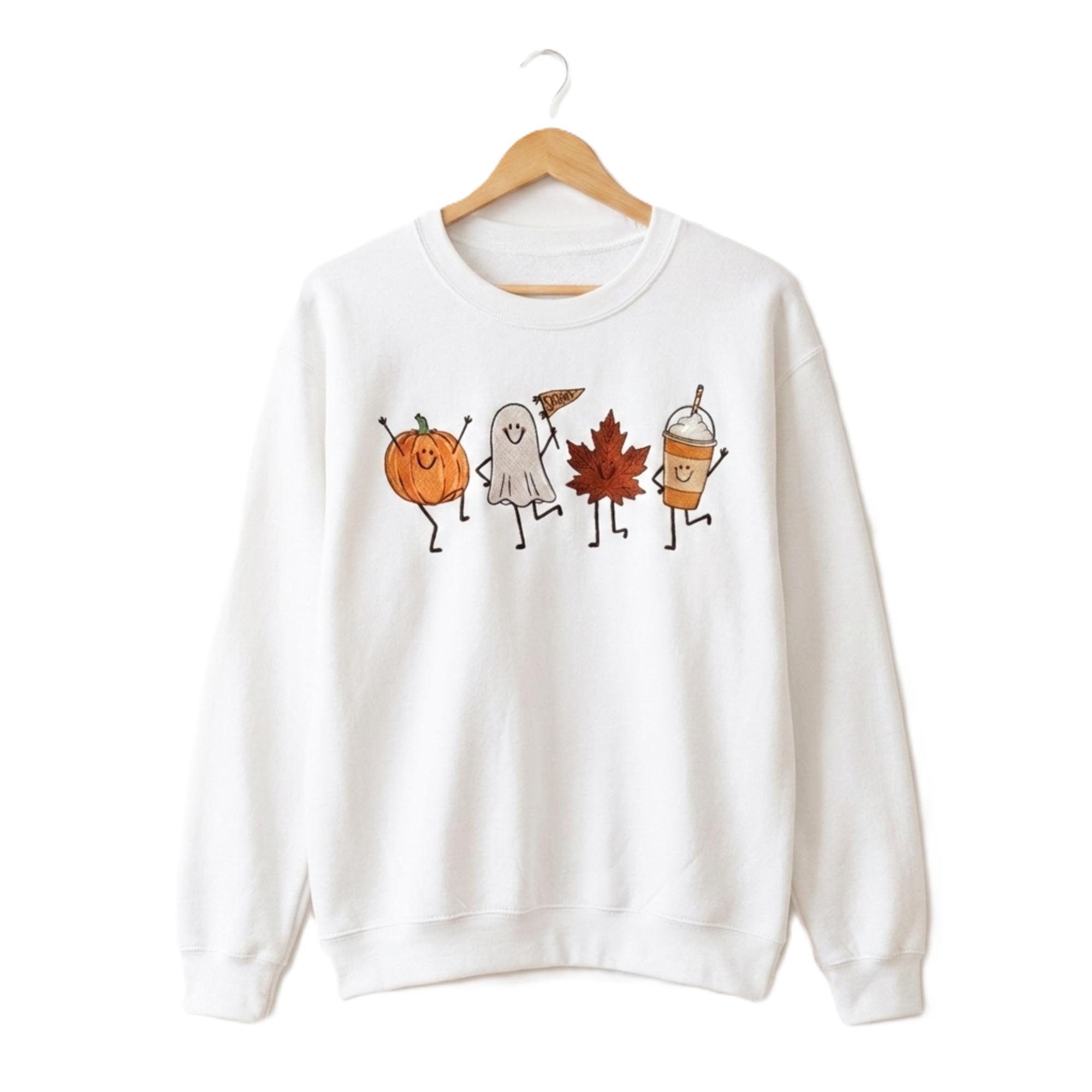 A white crewneck sweatshirt hanging on a wooden hanger against a plain white background. The sweatshirt features a graphic print of four cute, dancing autumn characters: a jack-o'-lantern, a ghost, a maple leaf, and an iced coffee cup.